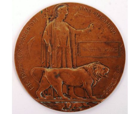 A WWI First World War Death Plaque / Penny. Awarded to an Ernest Thomas. Impressed ' M ' or ' W ' to verso. Soldier believed 