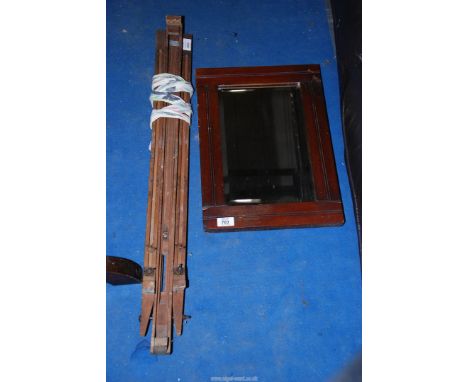 An easel and a bevelled wall mirror.