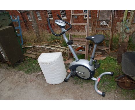An exercise bike and a Lloyd loom linen basket.