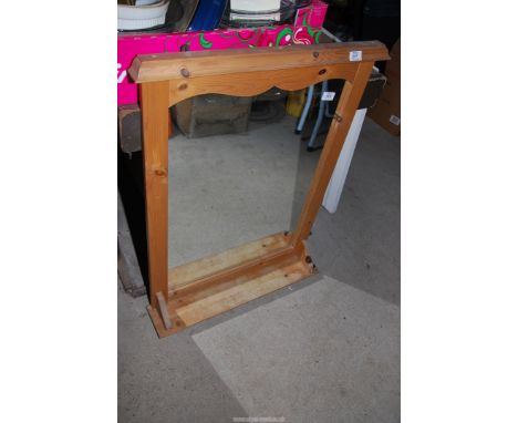 A pine framed mirror with shelf.