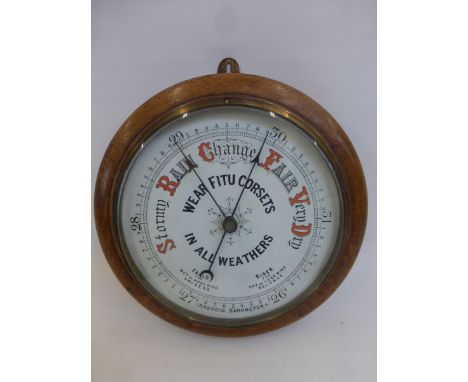 An oak framed circular wall barometer advertising Fitu Corsets.