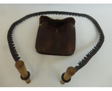 A Disston USA, military issue hand chainsaw, coil saw and a military leather pouch complete with file and tool. Stamped Disst