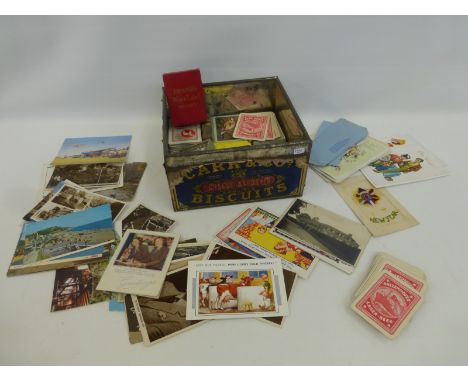 A selection of playing cards, some with advertising to the reverse, and a quantity of postcards.