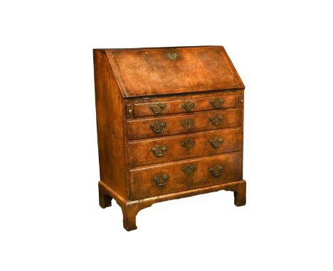 A George II walnut bureau, the slope front opening to reveal an arrangement of six pigeon holes and drawers around a central 