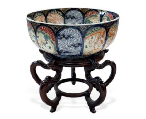 A Japanese porcelain bowl, circa 1900, painted with 12 arched panels alternately depicting phoenix birds, dragons and trellis
