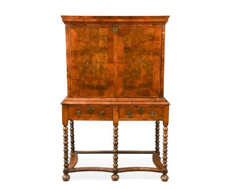 A walnut escritoire on stand, 17th century and later, the fall front enclosing a combination of drawers around a central cupb