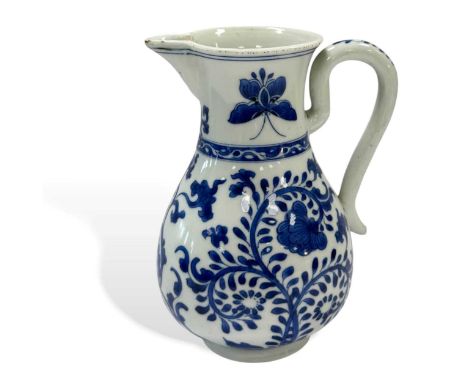 A Chinese blue and white export porcelain beer jug, Kangxi Emperor (1662-1722), painted with two butterflies to the neck and 