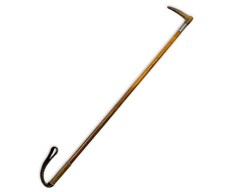 An Edwardian rhino horn mounted riding crop, with malacca shaft and leather tab, boot shape horn handle, the silver ferrule h