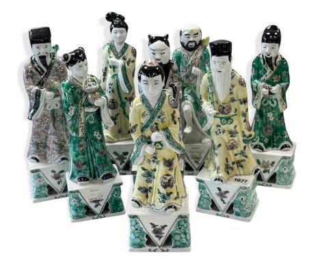 A set of eight Chinese famille verte style Daoist Immortals, each standing full length with attributes, on integral high plin