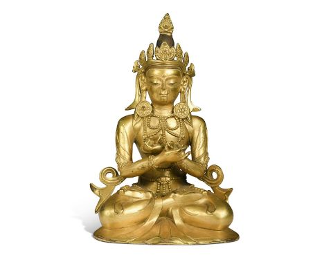 A Chinese large gilt bronze seated figure of a Bodhisattva, 20th century, wearing a crown, robes and jewellery, holding two v