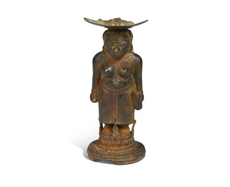 A Javanese Majapahit period Indonesian bronze and iron figure of a half nude woman, 14th century, standing full length wearin