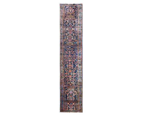 A very long Malayer runner rug, circa 1930, with an intricate floral design incorporating lotus flowers on a rich indigo fiel