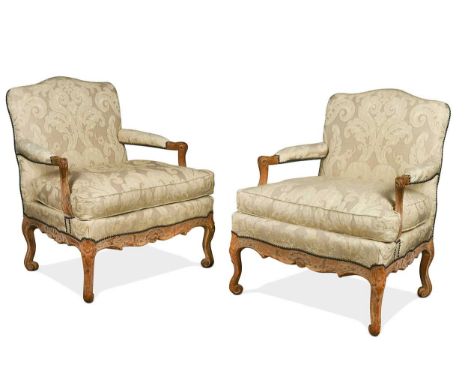 A pair of Louis XV style beech framed fauteuil armchairs, with carved armrests and downswept supports, the seats above a foli