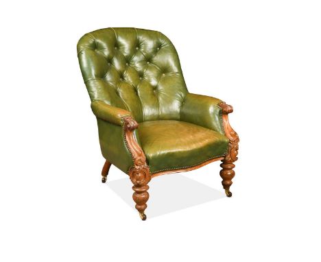 A Victorian mahogany button back tub armchair, the carved arms over turned front legs, upholstered in a studded green leather