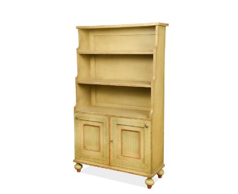 A Regency style painted waterfall bookcase, late 19th century, decorated with green floral borders, the graduating open shelv