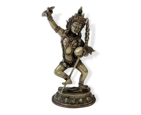 A Tibetan silvered metal figure of Vajravarahi dancing on a corpse, holding a kartrikka (chopper) and a kapala (skull cup), o