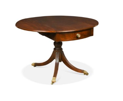 A Regency mahogany pedestal Pembroke table, the oval drop flap top raised on a turned column with four splayed reeded legs wi