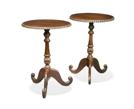 A pair of Ceylonese hardwood tripod tables, 19th century, the circular tops with ridged and moulded frieze, the knopped and t