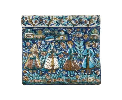 A Persian relief moulded tile, 19th century, moulded and painted with four court figures before palaces, below a border of bi