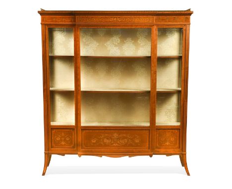 A late Victorian mahogany display cabinet, with gilt metal balustrade gallery, over a slight breakfront glazed section with s