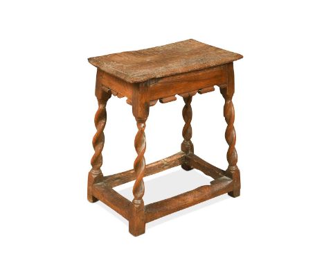 An oak joint stool, 17th century, with a shaped apron on barley twist legs united by a stretcher52 x 45 x 31cm