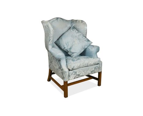 A George III style mahogany wing back armchair, upholstered in blue damask, the legs united by an H-frame stretcher110 x 86 x