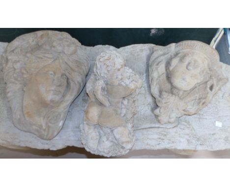 Three modern garden ornaments - a small cherub laying on a bed of grapes, jasmine - a wall mounted cherub face planter, a wal