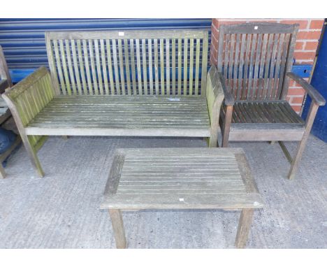 A teak slatted garden bench, chair and coffee table