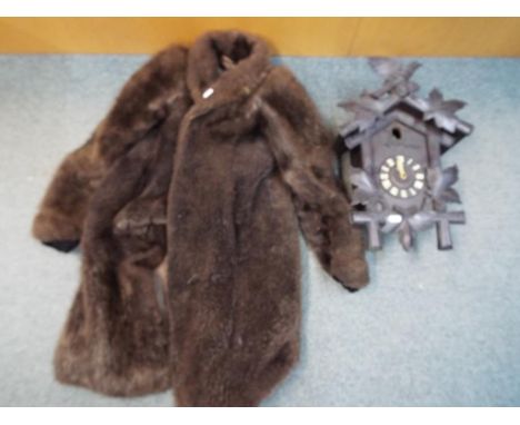 A Black Forest cuckoo clock and fur coat. [2]