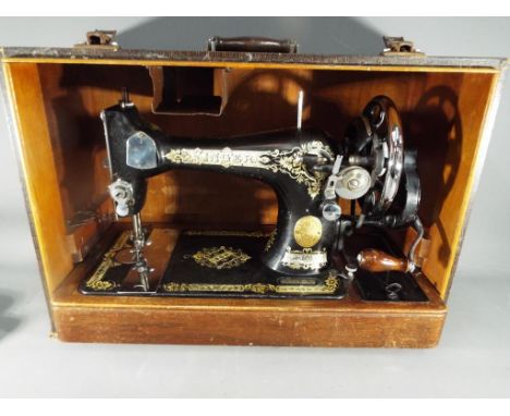 A vintage Singer sewing machine No. 28 model, serial number EC628983, contained in case with instructions.