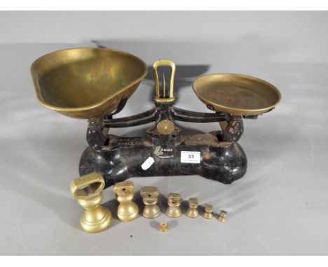 A set of Libra Scales Co cast iron weighing scales with brass pans with a set of seven brass Imperial weights.