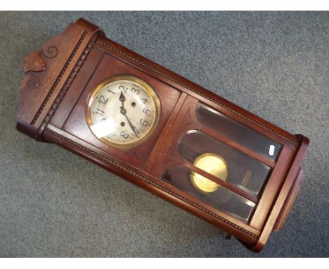 A mahogany cased wall clock, Arabic numerals, with key and pendulum.