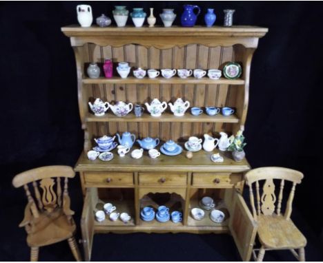 A small model of a pine dresser, approximately 70 cm x 46 cm x 17 cm, with a quantity of miniature ceramics to include Wedgwo