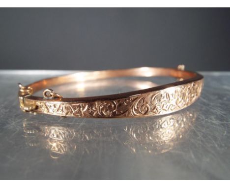 9 ct - a hallmarked 9 carat rose gold bangle with safety chain, approximate weight 5.2 g.Condition: Some denting and distorti