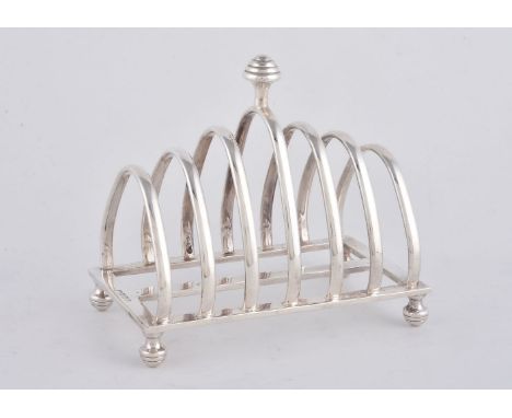 A silver six division toast rack, maker's mark CH (not traced), Birmingham 1998, with a 'turned' finial and conforming feet, 