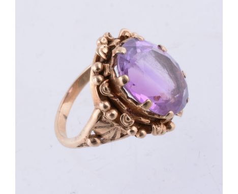 An amethyst single stone ring, the oval shape amethyst in a claw setting within a foliate border, finger size O, 6.8g gross