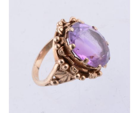 An amethyst single stone ring, the oval shape amethyst in a claw setting within a foliate border, finger size O, 6.8g gross