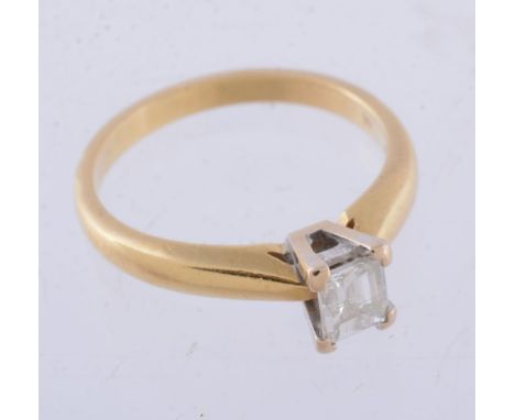 A diamond ring, the rectangular cut diamond, estimated to weigh 0.20 carats, in a four claw setting, stamped 750, finger size