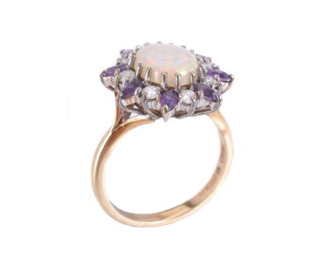 A 9 carat gold opal, amethyst and diamond ring, the oval shaped cabochon opal with a surround of alternate brilliant cut diam