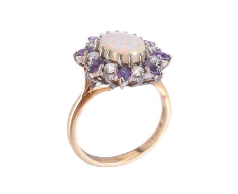 A 9 carat gold opal, amethyst and diamond ring, the oval shaped cabochon opal with a surround of alternate brilliant cut diam