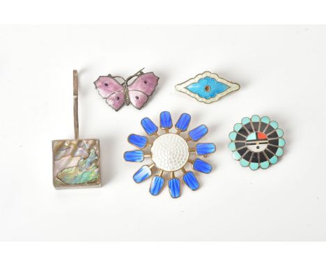 Four enamel brooches and an abalone shell pendant:- a circular Zuni inlay brooch inlaid with mother of pearl, coral, turquois