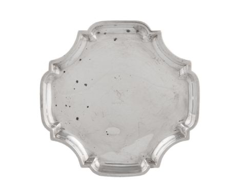 A silver waiter by William Comyns &amp; Sons, London, quatrefoil with incurved angles, engraved with a crest, on four stepped