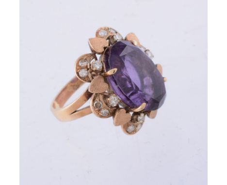 An amethyst and diamond ring, the oval cut amethyst claw set within a surround set with eight cut diamonds, stamped 14K, fing