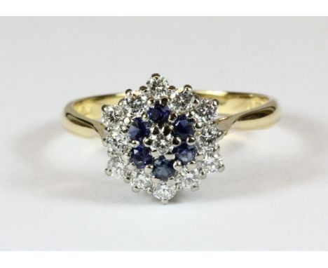 An 18ct gold sapphire and diamond cluster ring (T)