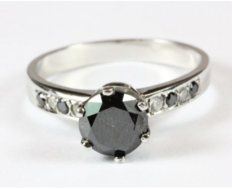 A white metal (tested min 9ct gold) large solitaire black diamond (approx 1ct) ring with black and white diamond set shoulder