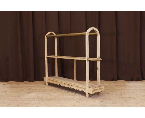 A large ash, brass and cane luggage stand, early 20th century, with a pair of tubular rails above two shelves, set between ar