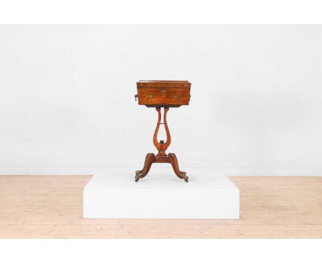 A Regency rosewood and cut-brass teapoy, c.1820, the hinged lid enclosing a fitted interior with caddies, raised on a lyre co