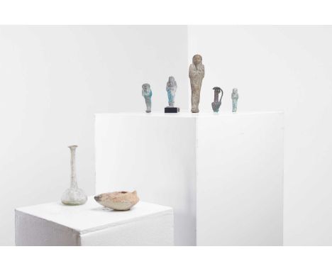 A group of antiquities, comprising a Roman glass bottle, four Egyptian faience shabtis, a small mould-blown green glass bottl