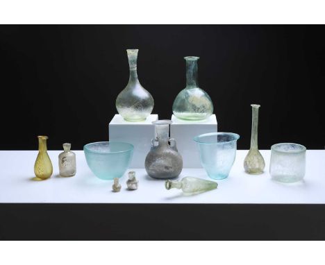 A collection of Roman glass vessels, comprising various bottles and bowls,tall bottle 8.5cm diameter16cm high (12)Provenance: