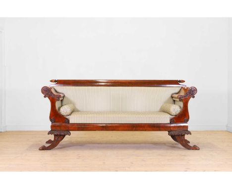 A Biedermeier mahogany settee, second quarter of the 19th century, with a pair of scrolling ends, raised on acanthus-capped s